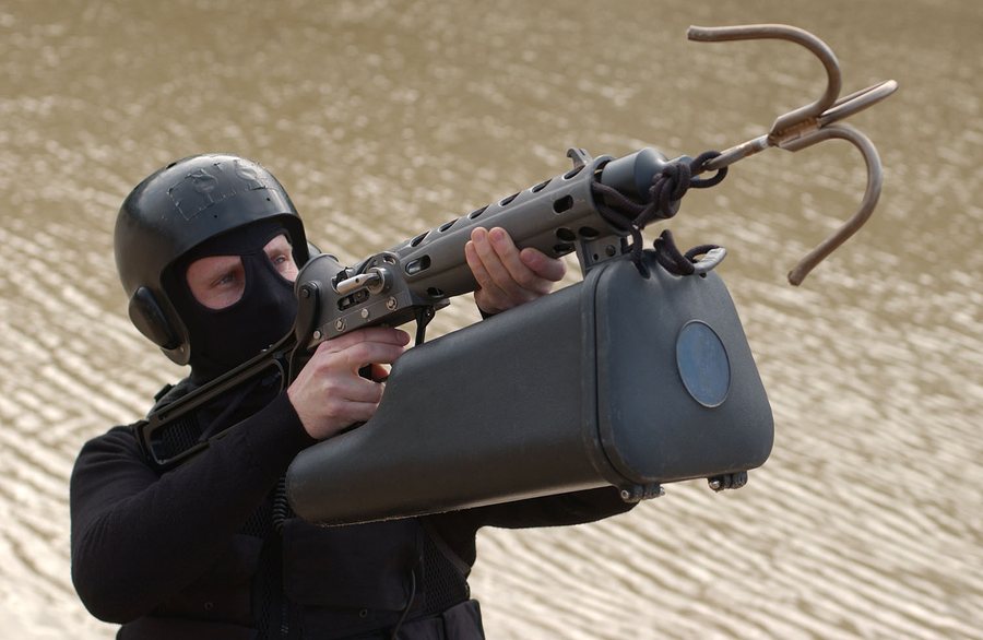 Operator aiming an ALM with a grappling hook over water