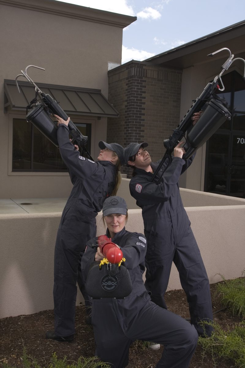 Three RSI team members in coveralls with two Tactical ResQmax launchers and a ResQmax launcher