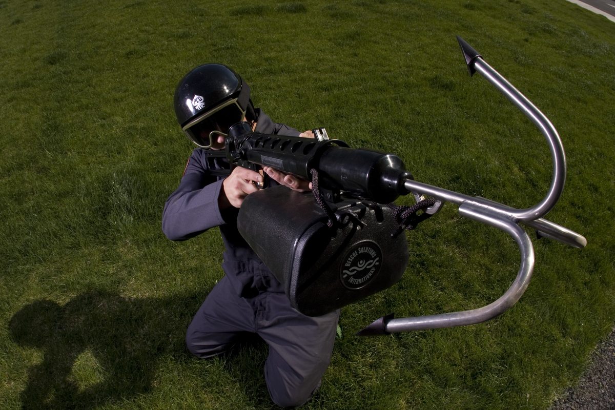 Operator kneeling and aiming a Tactical ResQmax with grappling hook