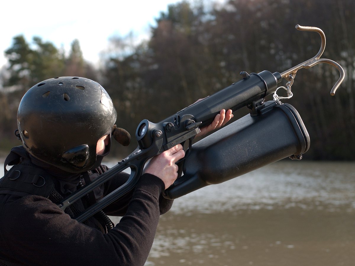 Operator aiming a Tactical ResQmax with a grappling hook across a river